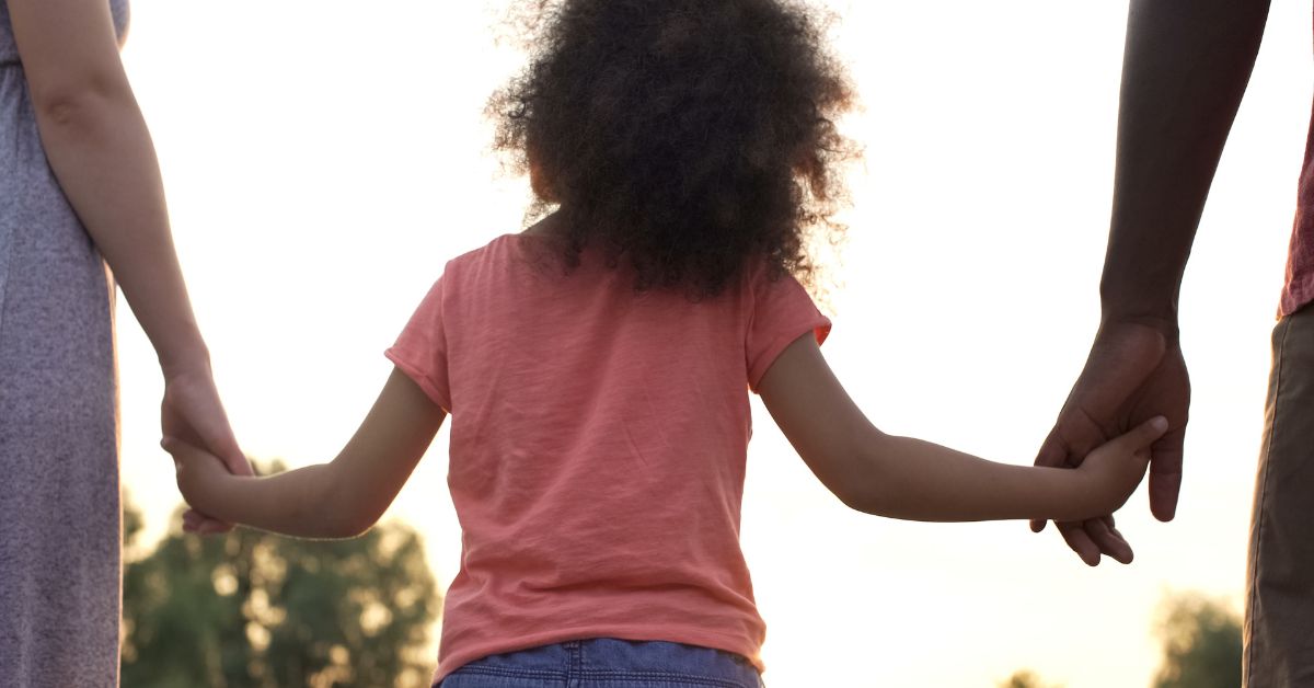 child holding hands with parents